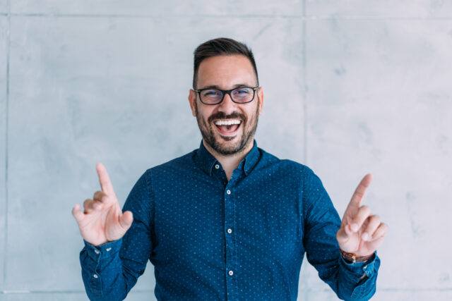 Handsome elegant male entrepreneur discussing while having a conference call in the office. Portrait of confident young male employee looking at camera  talking on video call in the office.